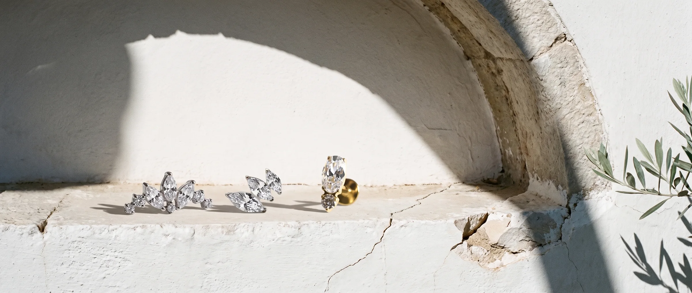 Diamond earrings on a sunlit stone ledge